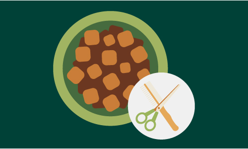 A green bowl filled with brown and tan chunks of pet food. In the bottom right corner, there is a circular icon featuring a pair of green scissors and a brown comb, symbolising grooming.
